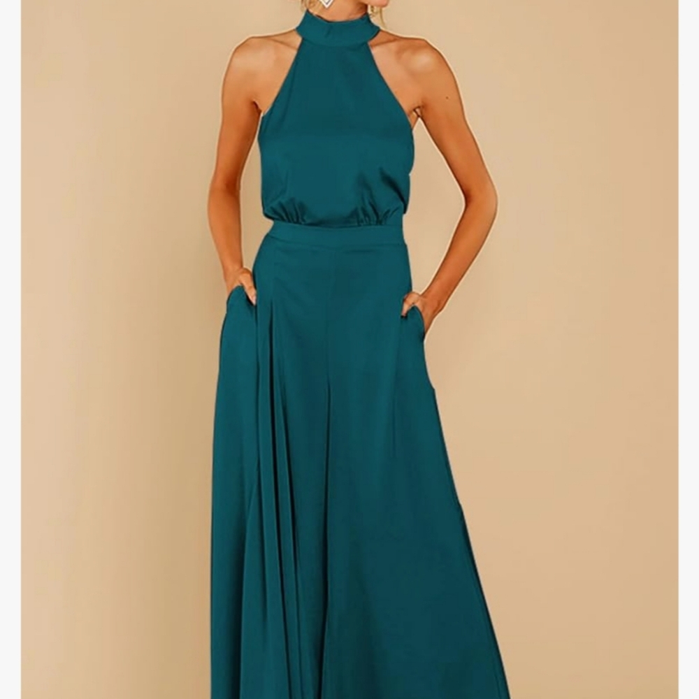 NWT. Stunning halter jumpsuit, sleeveless w/front pockets. Peacock Blue. Size M